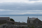 Looking back at the mainland a few buildings huddle on Lundy Island, England.